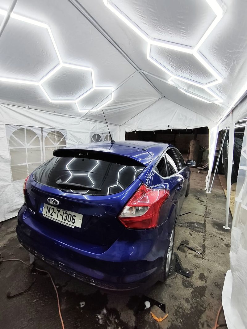 Blue Ford Focus with a tinted rear screen under the hex lights