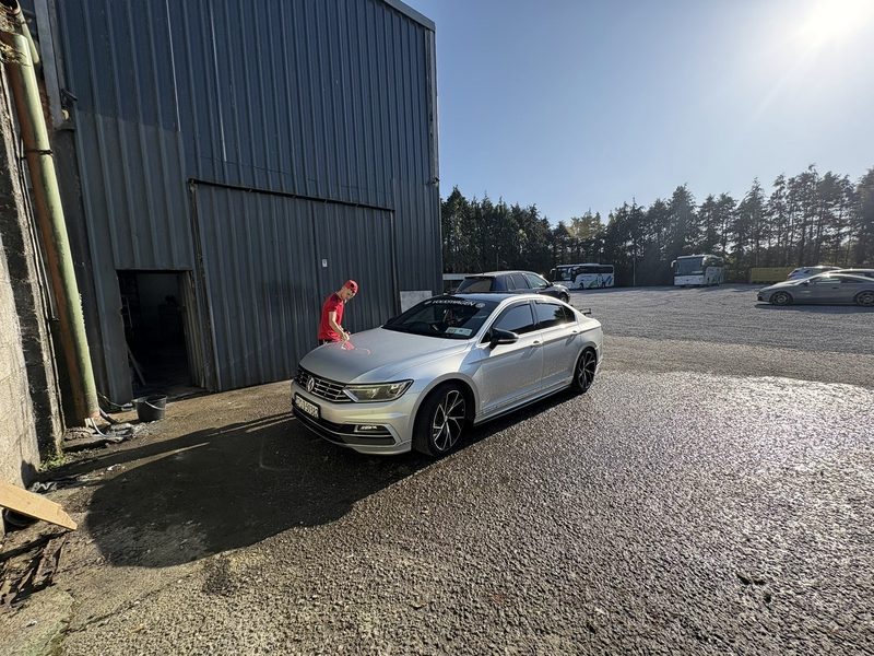 Nestor polishing a silver VW Passat outside the unit