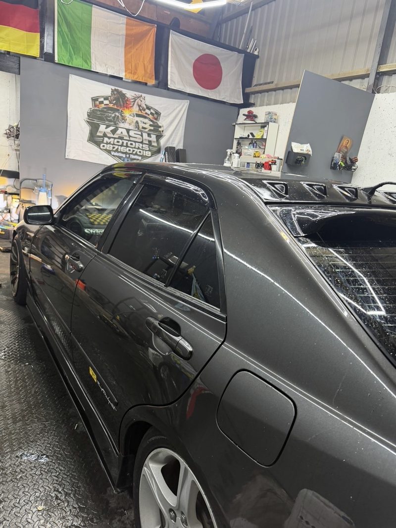 Inside the Kash Motors unit, with flags and the Kash Motors banner on the wall