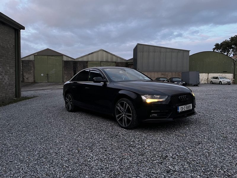 Black Audi A4 with its lights on in the yard outside the unit in Clonmel at dusk